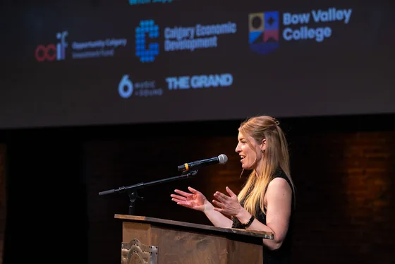 A speaker addressing the room from a lectern at The Alignment Event.