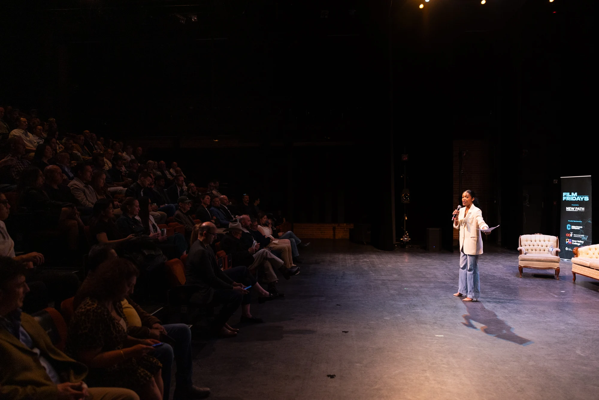 A speaker addressing the full theatre audience at Film Fridays’ Alignment Event.